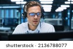 Small photo of Call Center Worker Wearing Headset Working in Office to Support Remote Customer. Call Center, Telemarketing, Customer Support Agent Provide Service on Video Conference Call.