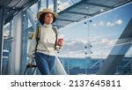 Small photo of Airport Terminal: Black Woman Holds Ticket, in a Hurry is Late and Runs Through Airline Hub to the Gates and to Her Airplane. African American Female Running for Flight to Vacation Destination