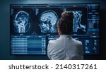 Small photo of Medical Hospital Research Lab: Black Female Neuroscientist Looking at TV Screen, Analyzing Brain Scan MRI Images, Finding Treatment for Patient. Health Care Neurologist Curing People. Back View Zoom