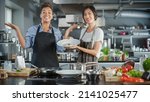 Small photo of TV Cooking Show Kitchen with Two Master Chefs. Asian and Black Female Hosts Talk. Professionals Teach How to Cook Food, Taste Delicious Dish. Online Video Class Courses. Healthy Dish Recipe Prepare