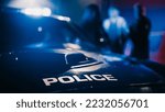 Small photo of Cinematic Focus on Patrol Car: Two Police Officers Arrest Suspect, Put Him in Vehicle. Officers of the Law Handcuff Dangerous Criminal on Dark City Street. Cops Fight Crime. Documentary Shot