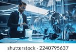 Small photo of Chief Engineer Using Laptop Computer, Analyzing and Researching How a Futuristic Turbofan Motor Works. Senior Manager Developing Innovative Technology in Industrial High Tech Facility.