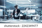 Small photo of Robotics Engineer Operating a Futuristic Robotic Arm, Using a Virtual Reality Headset and Controllers to Perform Tasks. Work in Research and Development High Tech Facility Startup.