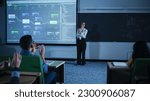 Small photo of Excited Diverse Class of Students Applauding to a Happy Young Post-Graduate Female Professor for Delivering a Moving Note-Worthy Presentation About Web Development and Management Roadmaps