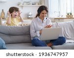 Small photo of Mother freelancer talking on video call, remote working on laptop from home office with kid during lockdown. Children make noise disturb woman at work, shows tongue standing behind couch. Distance job