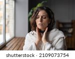 Small photo of Upset sick woman standing at home touching swollen glands, having pain or scratchy sensation in throat, selective focus. Female suffering from angina or tonsillitis caused by infection or irritation
