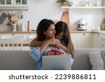 Small photo of Little girl daughter hugging embracing happy beloved mother with love and tenderness while celebrating special occasion together at home, child wishing happy birthday to mom, greeting with Mothers Day