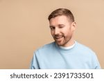 Small photo of Flirting man winks look at camera, studio portrait isolated on beige. Bearded middle aged guy smiling winking playfully jokingly impishly with one eye, hinting, hidden intent, non-verbal communication