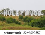 Hollywood inscription on a green hill in cloudy weather.