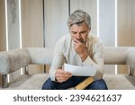 Small photo of stressed businessman opening envelope reading bad news in mail letter. Mad man feels frustrated about high bills, dismissal notice, bank debt, tax invoice or mistake
