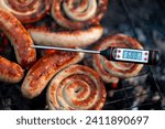 Close-up shot of a digital meat thermometer displaying a safe cooking temperature for grilled sausages