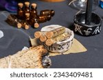 Small photo of Witchcraft potion vials or glass bottles with magic ingredients in the cup with magic symbols. Spiritual occultism and magic chemistry background. Alchemy and esoteric items. Occult esoteric concept.