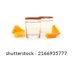 Small photo of Mezcal Mexican drink with orange slices and worm salt isolated on white background