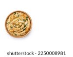 Small photo of Chickpea hummus in a wooden bowl garnished with parsley, paprika and olive oil isolated on white background. Top view. Copy space