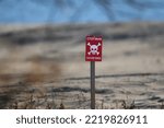 Small photo of A bright red "Danger-mines" sign was placed on the sandy beach of Odessa during the Russian attack on Ukraine. Putin sucks.
