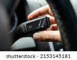 Small photo of male person adjusting car wipers speed. car wiper switch handle macro close up. windshield wipers speed control wheel. car interior.