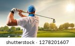 Small photo of Male golf player on professional golf course. Golfer with golf club taking a shot