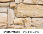 Small photo of Large rough stones, unsystematic masonry. Uneven surface. Old, ancient wall, fortress. Reliability, strength, protection.