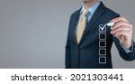 Small photo of Businessman Making Right Decision. Checklist concept, Businessman checking mark on check boxes. businessman ticking check box. man ticks square checkbox. Checklist concept, copy space. banner, grey