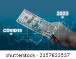 Small photo of inflation in 2022 and 2023. man holds one hundred dollar bill in hand against of graph chart of rising inflation rates. dollar hyperinflation on dark blue background. decreasing purchasing power