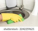 Cleaning. woman gloves hands cleaning kitchen sink. Cleaning home table, sanitizing kitchen table, surface with disinfectant spray bottle washing surfaces with towel and gloves