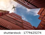 Airplane flying above container logistic. Cargo and shipping business. Container ship for import and export logistic. Logistic industry from port to port. Container at harbor for truck transport. 