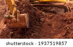 Small photo of Blur photo of backhoe working by digging soil at construction site. Bucket of backhoe digging soil. Crawler excavator digging on dirt. Excavating machine. Earth moving machine. Excavation vehicle.
