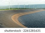 Small photo of HDPE plastic lined water reservoirs and landscape of wind farm for power generating stations. High density polyethylene engineering material. Wind power. Sustainable, renewable energy. Windmill farm.