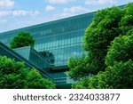 Small photo of Eco-friendly building in the modern city. Sustainable glass office building with trees for reducing heat and carbon dioxide. Office building with green environment. Corporate building reduce CO2.