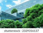 Eco-friendly building in the modern city. Sustainable glass office building with trees for reducing heat and carbon dioxide. Office building with green environment. Corporate building reduce CO2. 