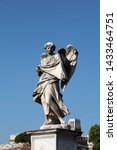 Small photo of The statue of the angel with the sudarium, the cloth used to wipe the face of Christ, on the Ponte Sant'Angelo. The baroque statue can be seen against a deep blue summer sky.
