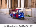 Small photo of A traditional ape taxi on the streets of Palermo, Italy.