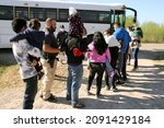 Small photo of La Joya, TX, USA - Nov. 16, 2021: A group of Central American families being transported to a processing center after turning themselves in to the Border Patrol to seek asylum boards a bus.