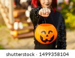 Closeup of unrecognizable little girl wearing Halloween costume and holding pumpkin basket in trick or treat season, copy space