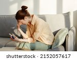 Minimal side view portrait of crying young woman holding pregnancy test at home, copy space