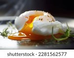 Small photo of A perfect poached egg with a velvety, golden yolk that is ready to be enjoyed, its surface just pierced.