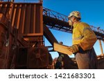 Small photo of Miner engineer planer holding a planing book while looking up crashing chute during shut down operation Sydney mite site, Australia