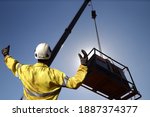 Small photo of Rigger wearing a glove standing raising using a hand signal by moving finger slowly to directing communication with crane driver to move the boom up at construction site, Sydney, Australia