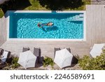Small photo of two people swim in the pool at the hotel. View from above, a couple of men and women in a swimming pool of a luxury vacation home in France Europe