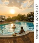 Small photo of Luxury country house with swimming pool in Italy. Pool and old farmhouse during sunset in central Italy. Couple on Vacation at a luxury villa in Italy, men and woman watching the sunset.
