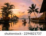 Luxury swimming pool in tropical resort, relaxing holidays in Seychelles islands. La Digue, Young man during sunset by swimpool Seychelles