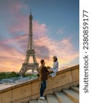 Small photo of Young couple by Eiffel Tower at Sunrise, Paris Eifel Tower Sunrise man woman in love, valentine concept in Paris the city of love. Men and women visiting the Eiffel Tower.