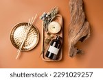 Small photo of Tray with scented home perfume in glass jar with rattan sticks. Luxury aroma oil home fragrance with woody and flowers notes concept.
