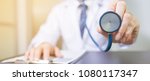 Small photo of A doctor holds his stethoscope to insinuate that it's time for a check up in clinic banner panoramic crop for copy space.