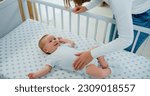 Top view. Mom playing to adorable newborn baby on bed smiling and happiness at home. Happy baby boy smile and laugh loudly.