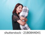 Small photo of Portrait of sleepy attractive Asian woman wearing pajamas, holding bolster falling asleep
