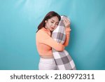 Small photo of Portrait of sleepy attractive Asian woman wearing casual top, holding bolster falling asleep