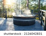 Small photo of Modern big barrel outdoor hot tub in the middle of forest. The hot tub's soothing warm water relaxes muscles and eases tensions, so your worries can simply melt away.