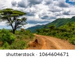 Remote rural area near Siracho Escarpment, Baringo County, Kenya looking across the Great Rift Valley. The rough dirt road is rocky and off the beaten track. Storm brewing. Natural landscape scenery. 