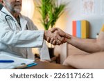 Small photo of Friendly male doctor's hands holding male patient's hand for encouragement and empathy. Partnership, trust and medical ethics concept. Bad news lessening and support. Patient cheering and support